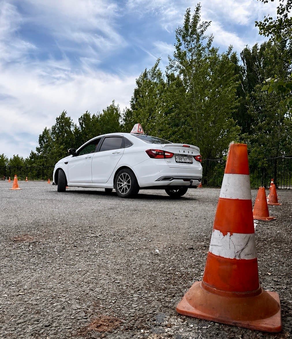 Учебный автомобиль выполняет упражнение с конусами